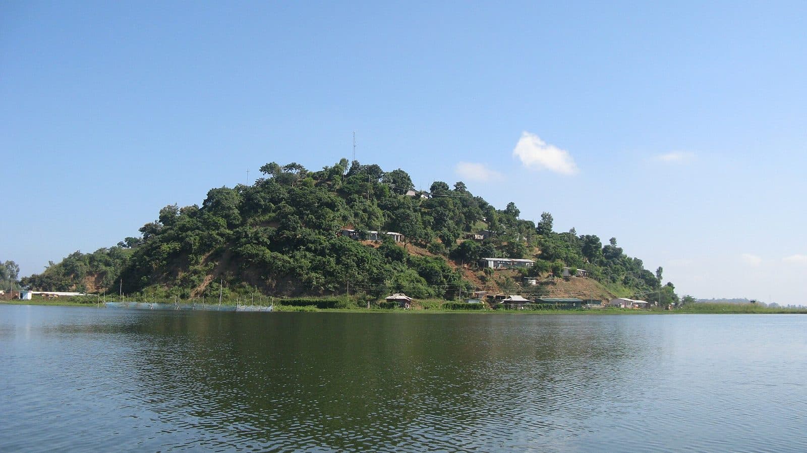 A wooded island rising from the calm water of Loktak Lake
